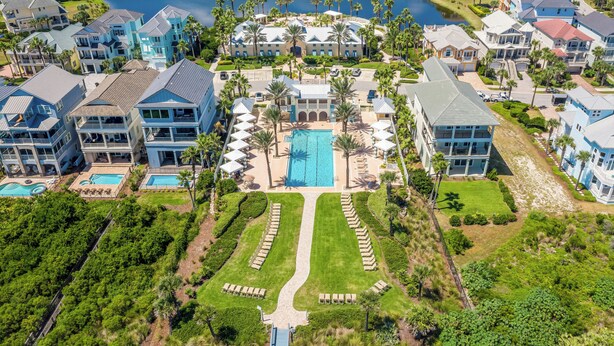 An aerial view of a resort with multiple buildings, a central pool, and well-maintained lawns. - Renovated - 4th Floor Condo #143 with Golf & Ocean Views at Cinnamon Beach (Palm Coast)