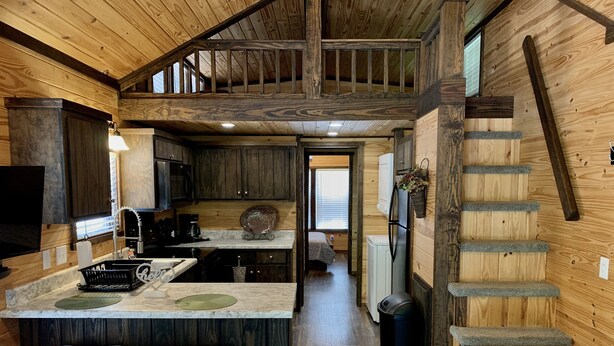L’intérieur d’une cabane comprend une cuisine, un coin bar et un escalier menant à une mezzanine.