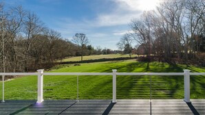 A deck with a white railing overlooking a green lawn and trees. - Costal Country Summer Home with Beach Access - 3 building compound (Westport)
