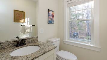 Een bad/douchecombinatie, een haardroger, handdoeken, zeep