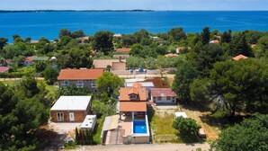 An aerial view of a coastal residential area with houses, a swimming pool, and a view of the sea. - Nina in Peroj  - Haus für 6 Personen (Fazana)