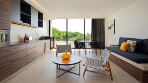 Una cucina moderna con zona pranzo, divano e un'ampia finestra vista sul verde.