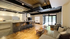 A modern apartment with a kitchen, dining area, and living room. - b hotel Kaniwasou | Miyajima Island Stay 11 (Hatsukaichi)