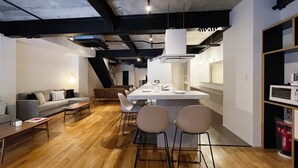 A modern interior with a dining area, kitchen, and living space. - b hotel Kaniwasou | Miyajima Island Stay 11 (Hatsukaichi)