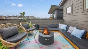 A rooftop patio with a fire pit, wicker chairs, a sofa, and a view of the city skyline. - The Jolene – Rooftop w/ Firepit, Close to 12 South (Nashville)