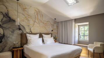 Ein modernes Schlafzimmer mit einem großen Bett, einer Marmorwand, einem Oberlicht und Blick auf Grün durch ein Fenster.