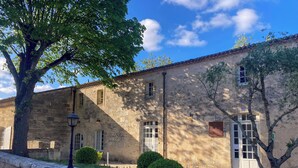 A stone building with a courtyard, a tree, and a lamp post. - Aux Ducs De Sienne (Montagne)