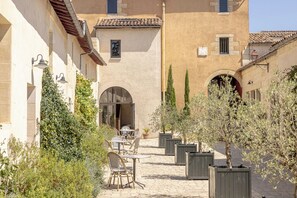 Un patio con asientos al aire libre, paredes de piedra y arcos.