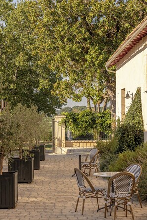 Un patio al aire libre con mobiliario de mimbre y un camino de adoquines.