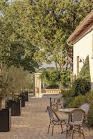 Un patio al aire libre con mobiliario de mimbre y un camino de adoquines.