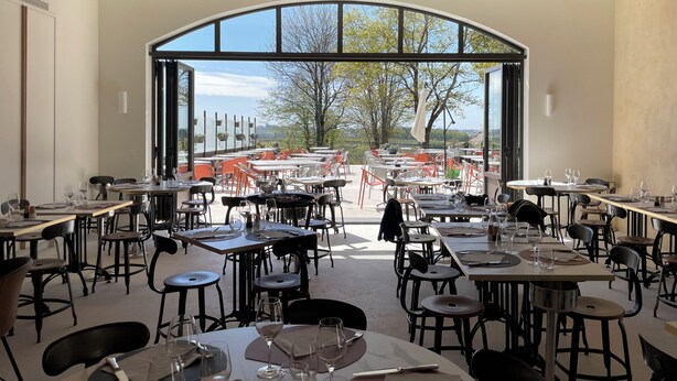 A restaurant with tables and chairs arranged for dining, large windows offering a view of the outdoors, and a ceiling with recessed lighting. - Aux Ducs De Sienne (Montagne)