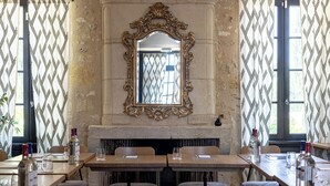 Un comedor con chimenea, un espejo grande y decorativo, y cortinas estampadas.