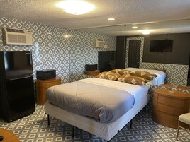 Cubrecamas, muebles diferentes y espacio para trabajar con laptop 
