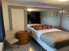 Cubrecamas, muebles diferentes y espacio para trabajar con laptop 