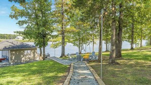 Una proprietà sul lago con un molo, posti a sedere all'aperto e una struttura in legno.