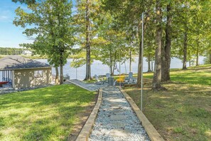 A lakeside property with a dock, outdoor seating, and a wooden structure. - 6 Bedrooms, Lakefront, Hot-Tub & Private Dock (Semora)