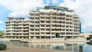 Ett hotell med flera våningar, balkonger, utsikt över vattnet och en modern arkitektonisk design.