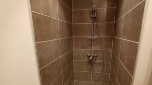 A small, enclosed shower area with brown tiles and a white floor. - Aux Pierres de Noziières  (Gramat)