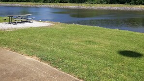 A grassy area with a picnic table and a concrete path.