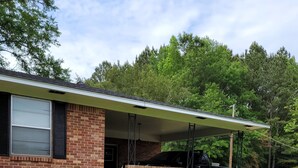 A single-story brick house with a covered porch and a small front yard.