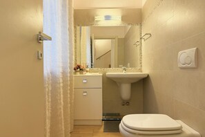 Un baño con inodoro, lavabo y espejo.
