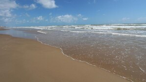 Una spiaggia con un'ampia distesa di sabbia e onde tranquille.
