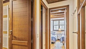 A hallway leading to a bedroom with a bed, bedside table, and window. - Luderna - Apartamento Val de Ruda B14 Paulet (Baqueira)