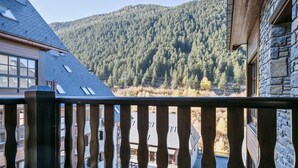 En balkon med udsigt over et skovklædt bjerg.