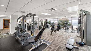 A gym with various exercise equipment, large windows, and a view of the ocean. - Seawind 300 by Liquid Life (Gulf Shores)