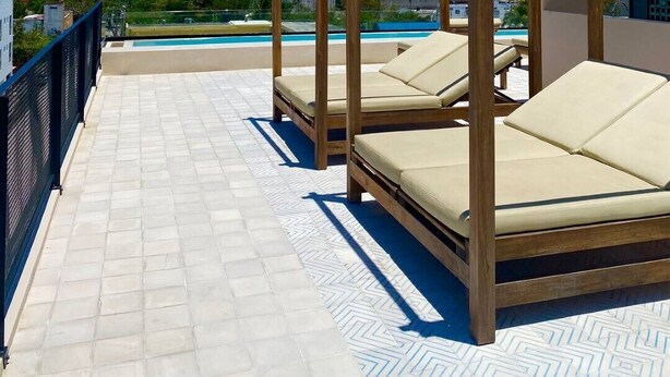 A rooftop terrace with wooden pergolas, lounge chairs, and a pool. - 1 Bedroom apartment with views to green area and hamacs, Gym, Rooftop Pool (Playa del Carmen)