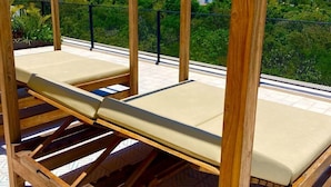 A wooden deck structure with a single lounge chair. - 1 Bedroom apartment with views to green area and hamacs, Gym, Rooftop Pool (Playa del Carmen)