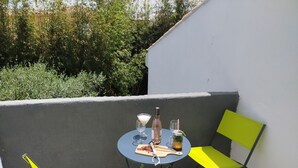 A small outdoor seating area with a table and two chairs, a bottle, a glass, and a jar on the table. - T2 R+1 for 2/4 pers, private garden and parking! (Nîmes)