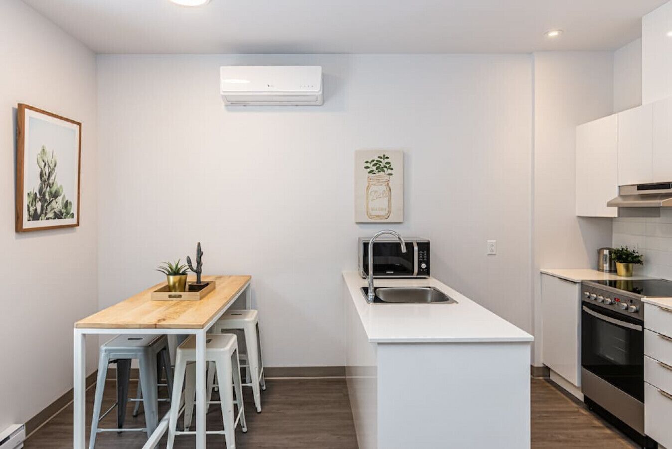 A compact kitchen with a central island, a microwave, a sink, and a stove.