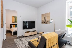 2 habitaciones, escritorio y tabla de planchar con plancha
