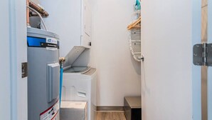 A compact laundry room with a PreLite washer, a dryer, and a metal rack for hanging clothes. - St-Denis 209 · Amazing New Apartment Close to Mount Royal (Le Plateau) by Denstays (Montréal)