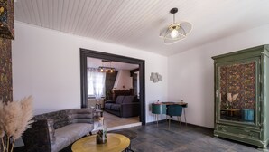 Un salon moderne avec un canapé, une table basse ronde et un meuble vert.
