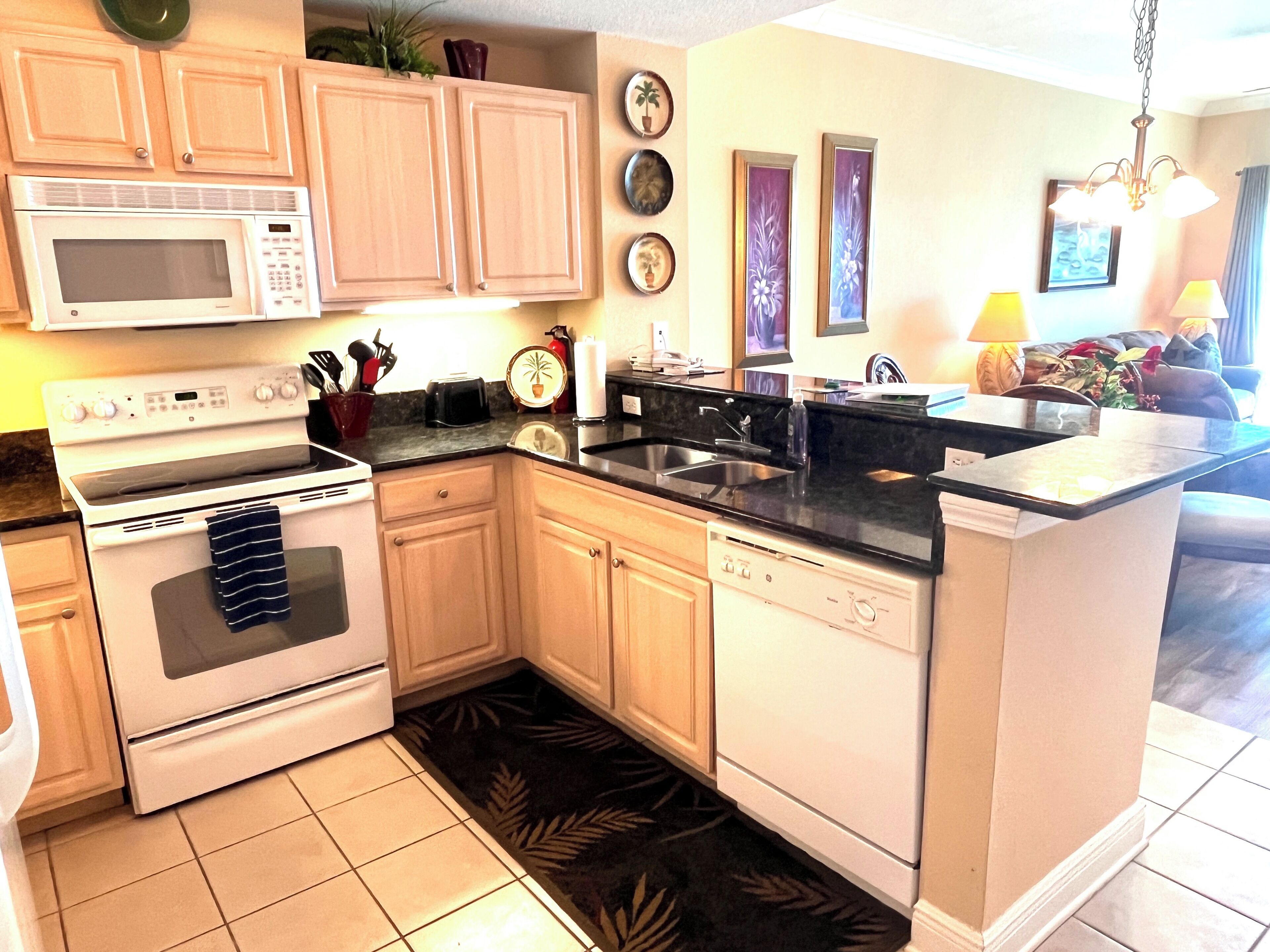 A kitchen with wooden cabinets, a microwave, stove, and dishwasher.