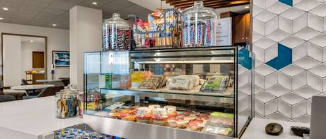 A hotel breakfast area with a variety of food items and beverages.