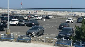 Un parcheggio con diverse auto e vista sulla spiaggia sullo sfondo.