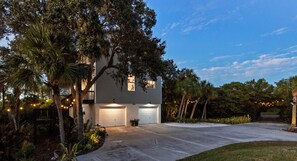 A two-story house with a garage, surrounded by trees and a well-maintained lawn.