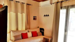 Ein gemütliches Zimmer mit einer Couch, einem kleinen Tisch und einem Bett.