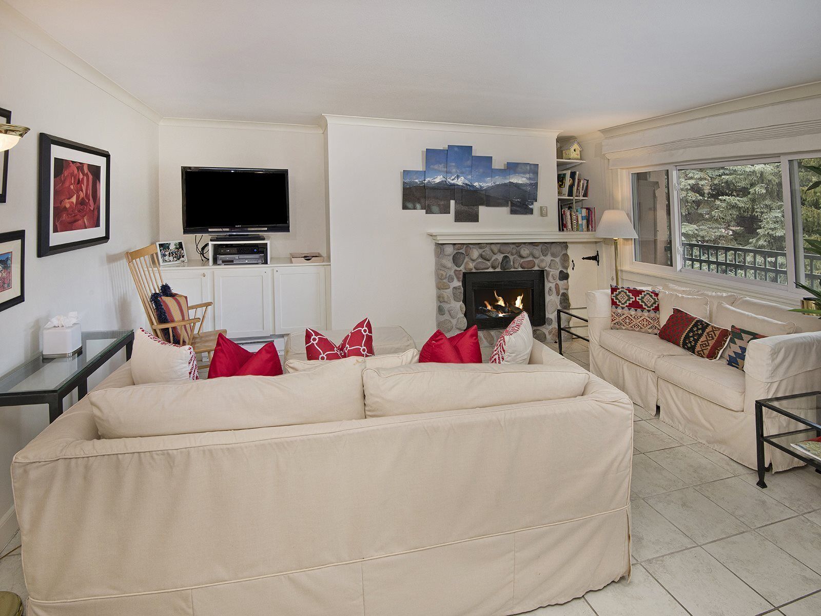 A living room with a fireplace, a television, and a sofa set.