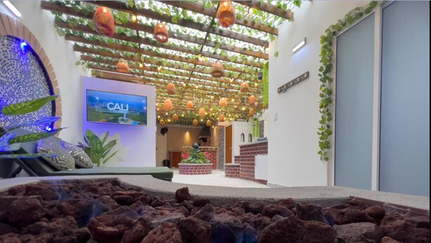 Een modern interieur met een stenen fontein, een televisiescherm en een open haard van baksteen.
