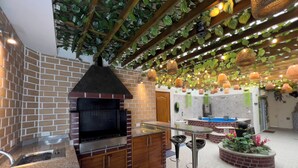 Een keuken met een bakoven, houten kasten en een bar met krukken.