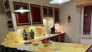 A kitchen with a large island, four chairs, a coffee maker, and a bowl of oranges. - Farm house, 5 miles from Avignon! Vineyard (Jonquerettes)
