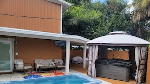 Ein Garten mit Schwimmbad, Sitzgelegenheit im Freien und Whirlpool.