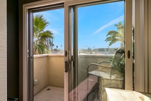 A balcony with a view of palm trees and a cityscape. - Across from the beach, a/c, gated parking and pets (San Diego)