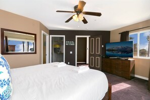 A hotel room with a large bed, a ceiling fan, a television, and a view of the outdoors. - Across from the beach, a/c, gated parking and pets (San Diego)