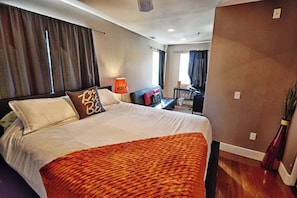 Een hotelkamer met een groot bed, een bureau en een stoel.