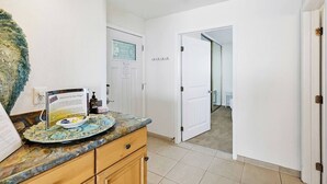 A hotel room with a marble countertop, a welcome sign, a door with a sign, and a view into the hallway. - New photos! Oceanfront condo with parking and pool (San Diego)